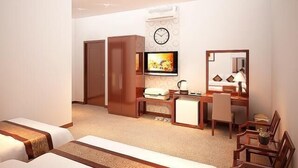 A hotel room with two beds, a desk, a chair, a TV, a clock, and a mirror. - Asia Hotel Can Tho (Can Tho)
