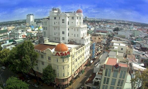 A large, historic building with a prominent dome and the name "Asia Hotel" on its facade.