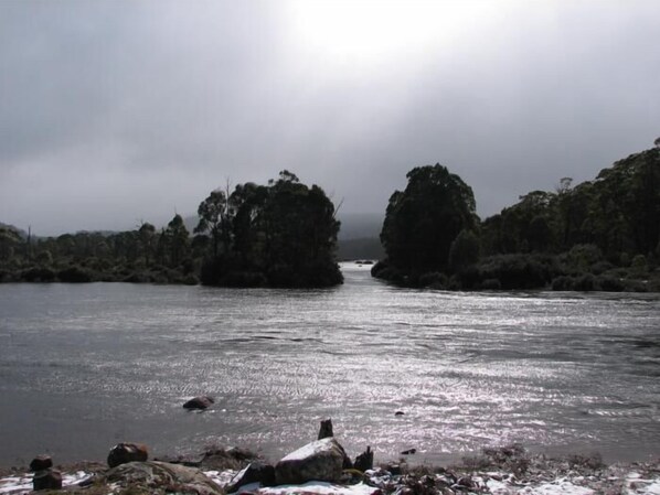 A river with rocky outcrops and dense vegetation on both sides. - Derwent Bridge Chalets & Studios (Derwent Bridge)