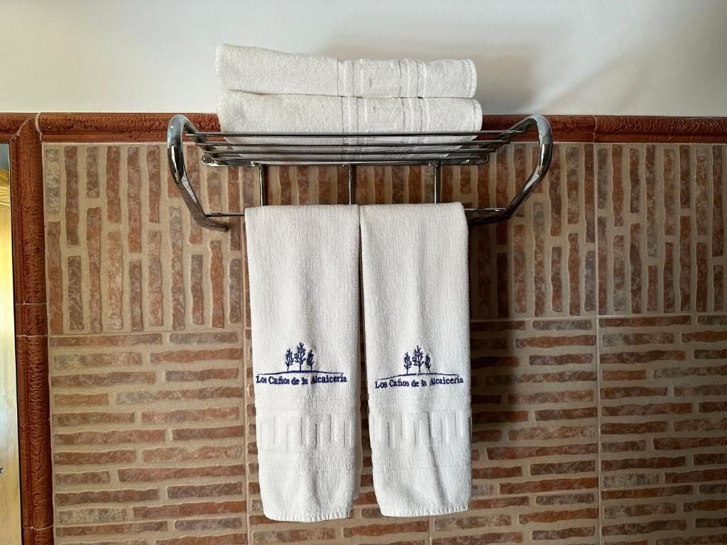 Ein Handtuchhalter mit zwei Handtüchern und einem darüberliegenden zusammengeklappten Handtuch.