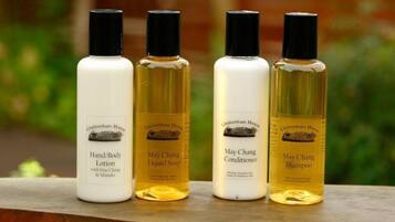 Four bottles of Cheltenham House products: Hand/Body Lotion, May Chang Liquid Soap, May Chang Conditioner, and May Chang Shampoo.