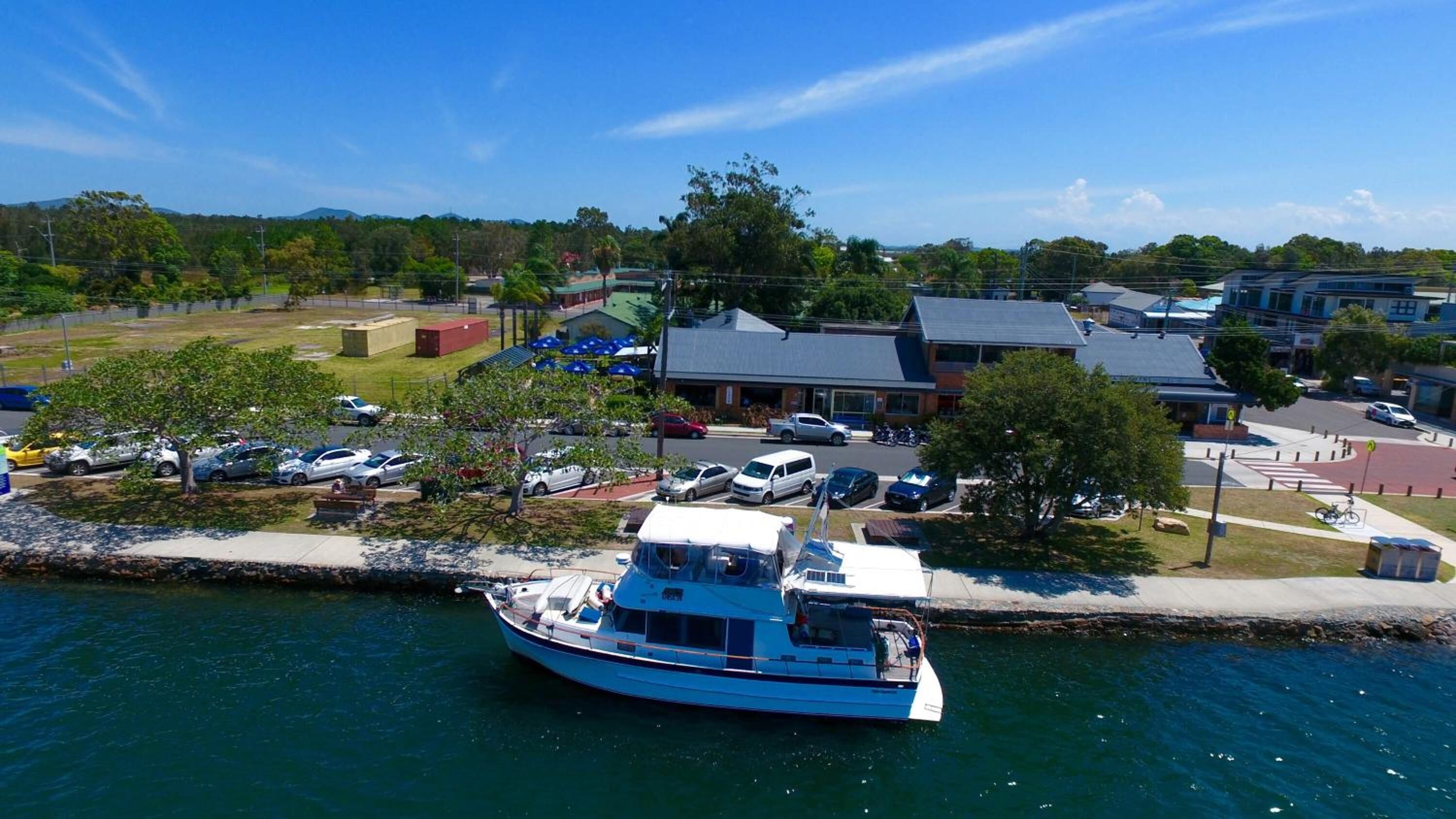 A boat docked at a marina with a building in the background.