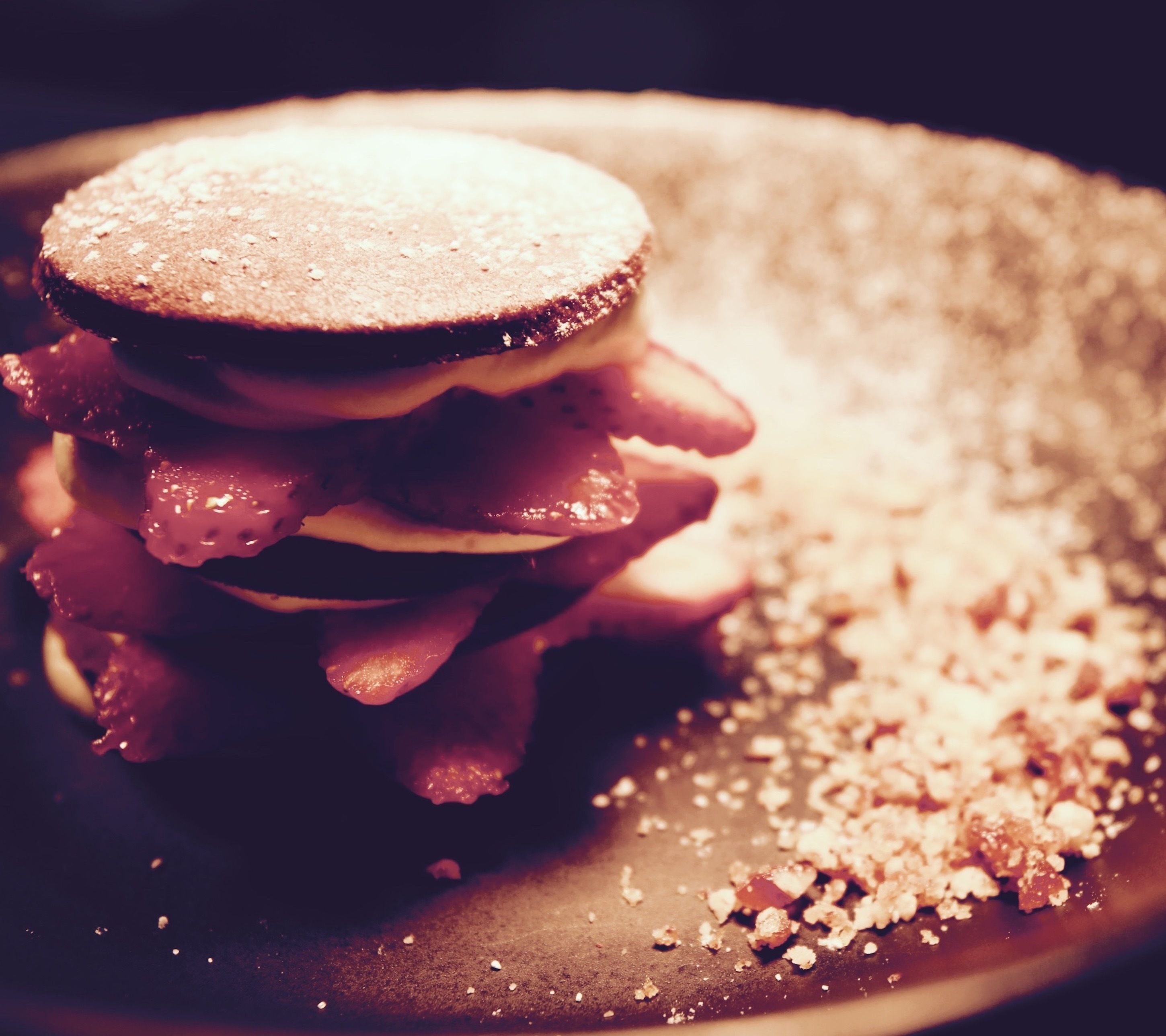 A dessert with layers of cake and cream, dusted with powdered sugar.