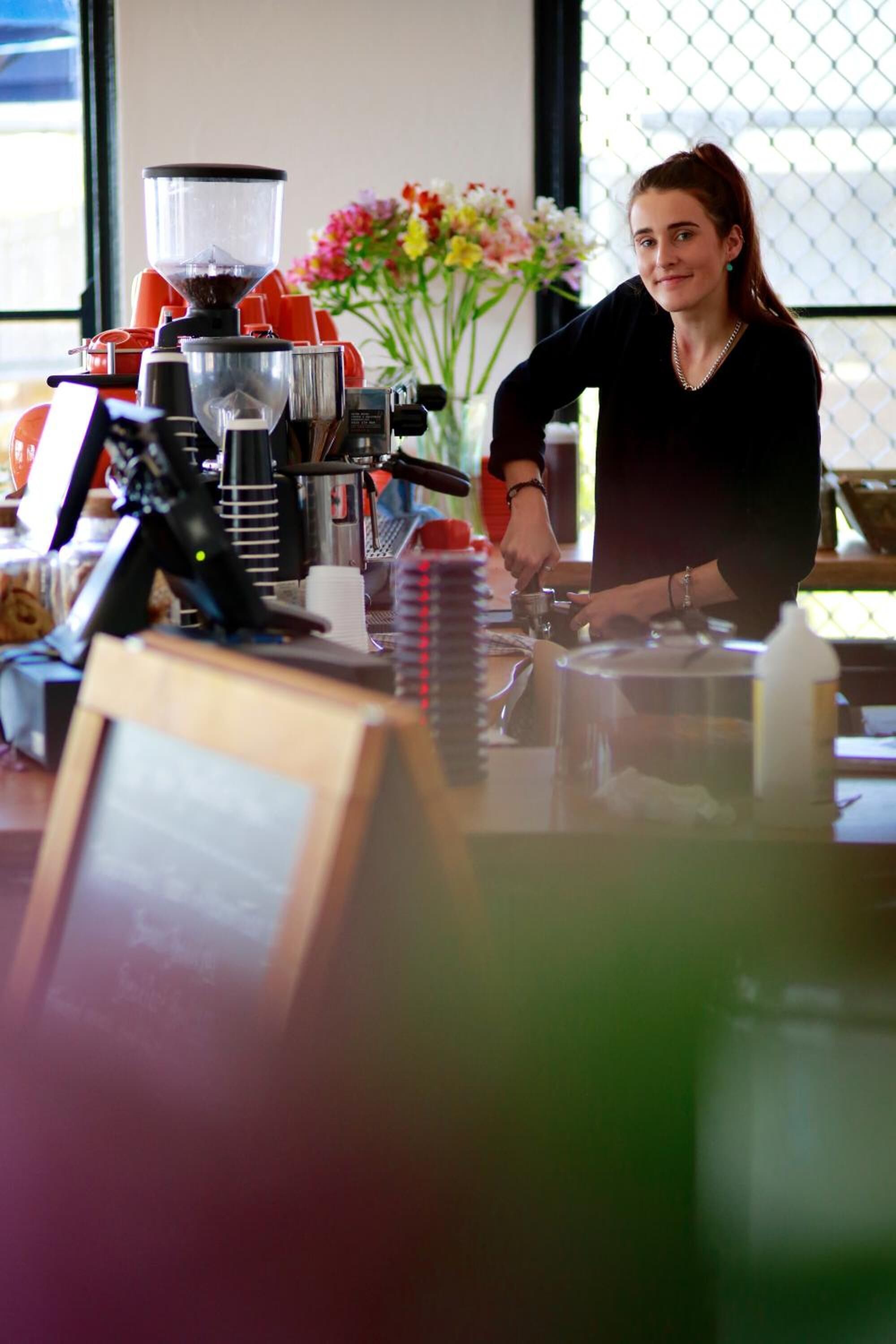 A coffee machine and a person preparing coffee.