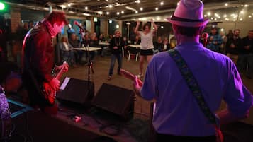 Una banda tocando en un local con techo rústico y mesas dispuestas para el público.