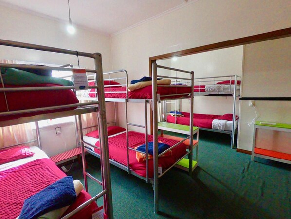 Un dormitorio con literas, una ventana y una puerta.