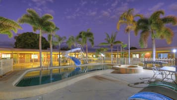 Una piscina al aire libre, sillones reclinables de piscina