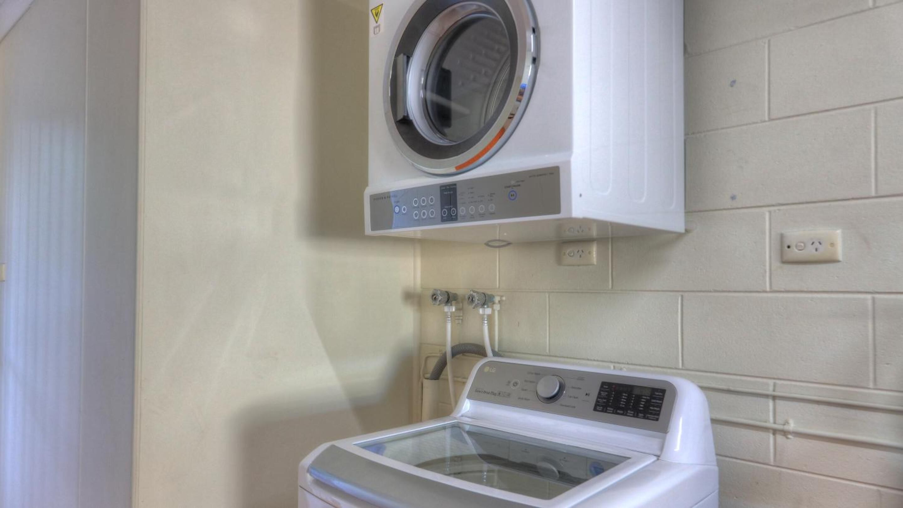 A laundry area with a front-loading washing machine and a top-loading dryer.
