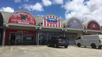 A commercial building with multiple storefronts including a Chinese takeaway, noodle bar, and Brazilian beauty salon.