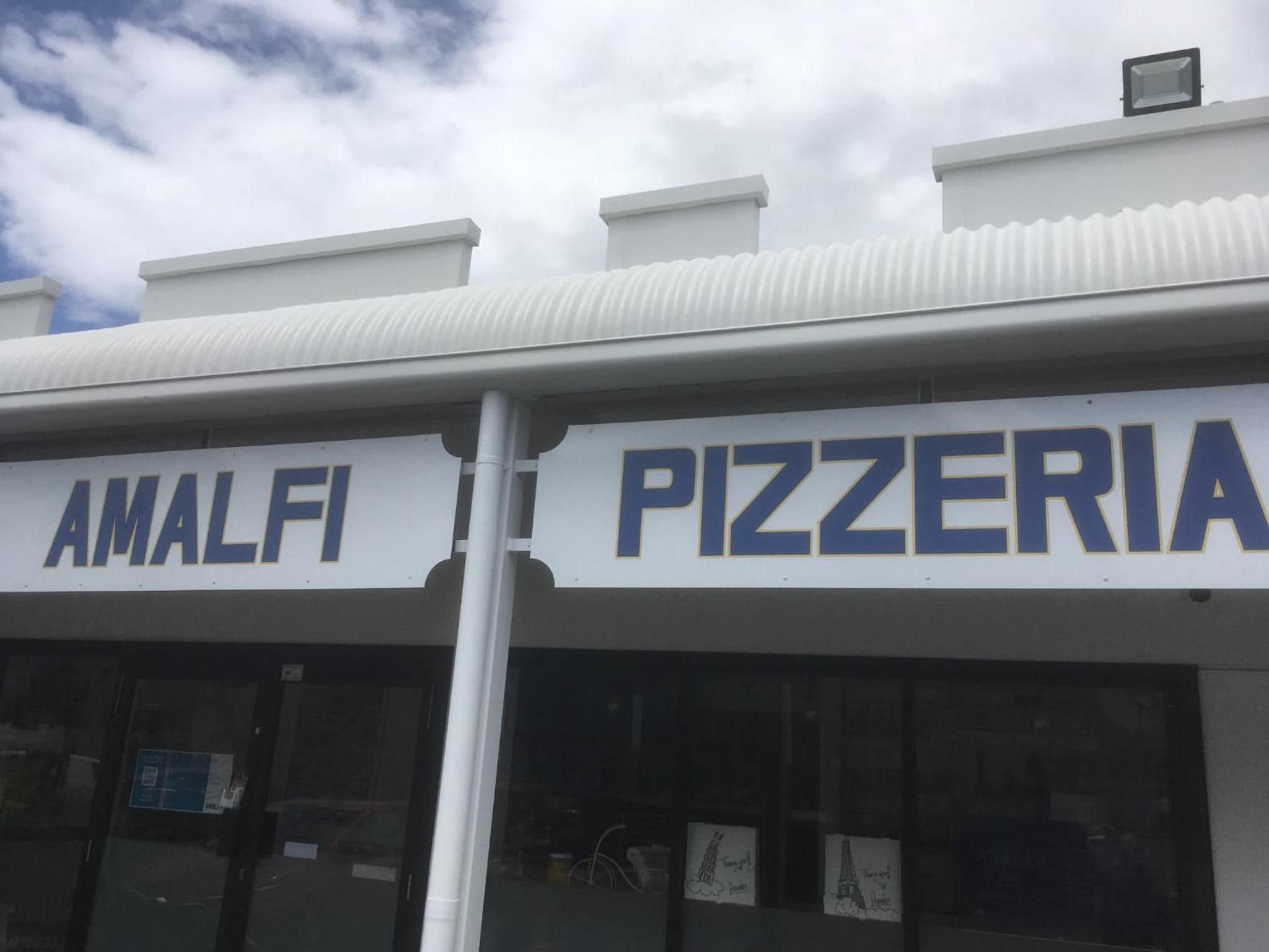 A storefront with 'AMALFI PIZZERIA' signage.