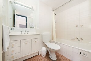 A bathroom with a toilet, sink, and shower.