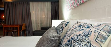 Habitación de hotel con cama, silla, escritorio y pared con diseño.