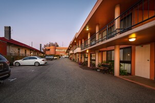 Un hotel con un patio central, varios balcones y una hilera de habitaciones a cada lado.