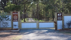 A gated entrance to a property named 'Hunt Valley' with signs indicating '47 Coulson Road Pokolbin' and '47 776 552'.