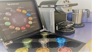A Nespresso coffee machine with a display of various coffee capsules.