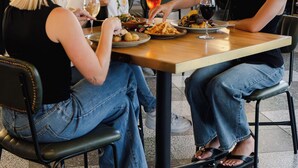 Un comedor con mesas, sillas y un techo decorativo.