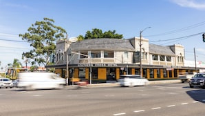 Un hotel con fachada curva, una entrada destacada y un cartel que dice 'Southern Cross Hotel'.