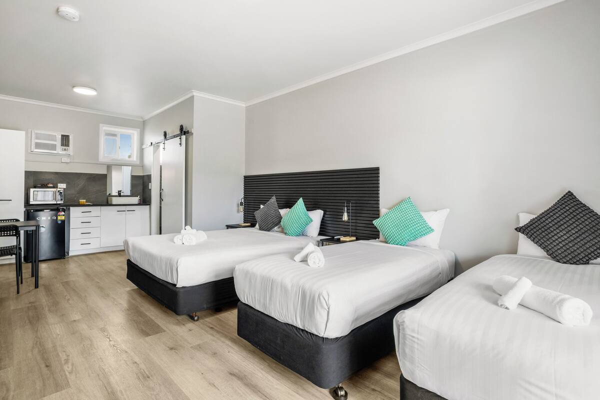 Une chambre d’hôtel avec deux lits, une kitchenette et une salle de bain.