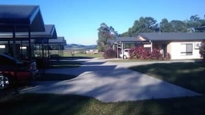 A building with a covered parking area and a small adjacent structure. - Atherton Holiday Park (Atherton)