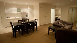 A compact living space with a dining area, kitchenette, and a sofa.