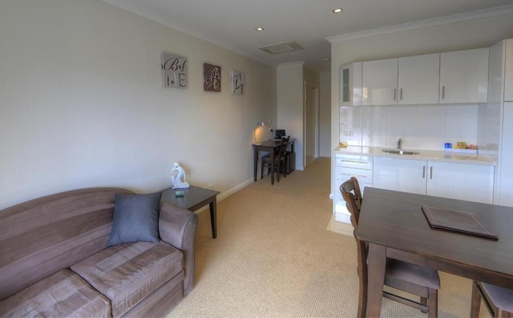 A compact living space with a sofa, a dining table, and a kitchenette.