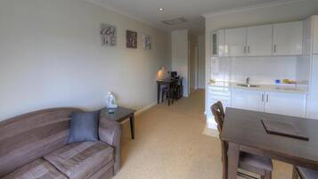 A compact living space with a sofa, a dining table, and a kitchenette.