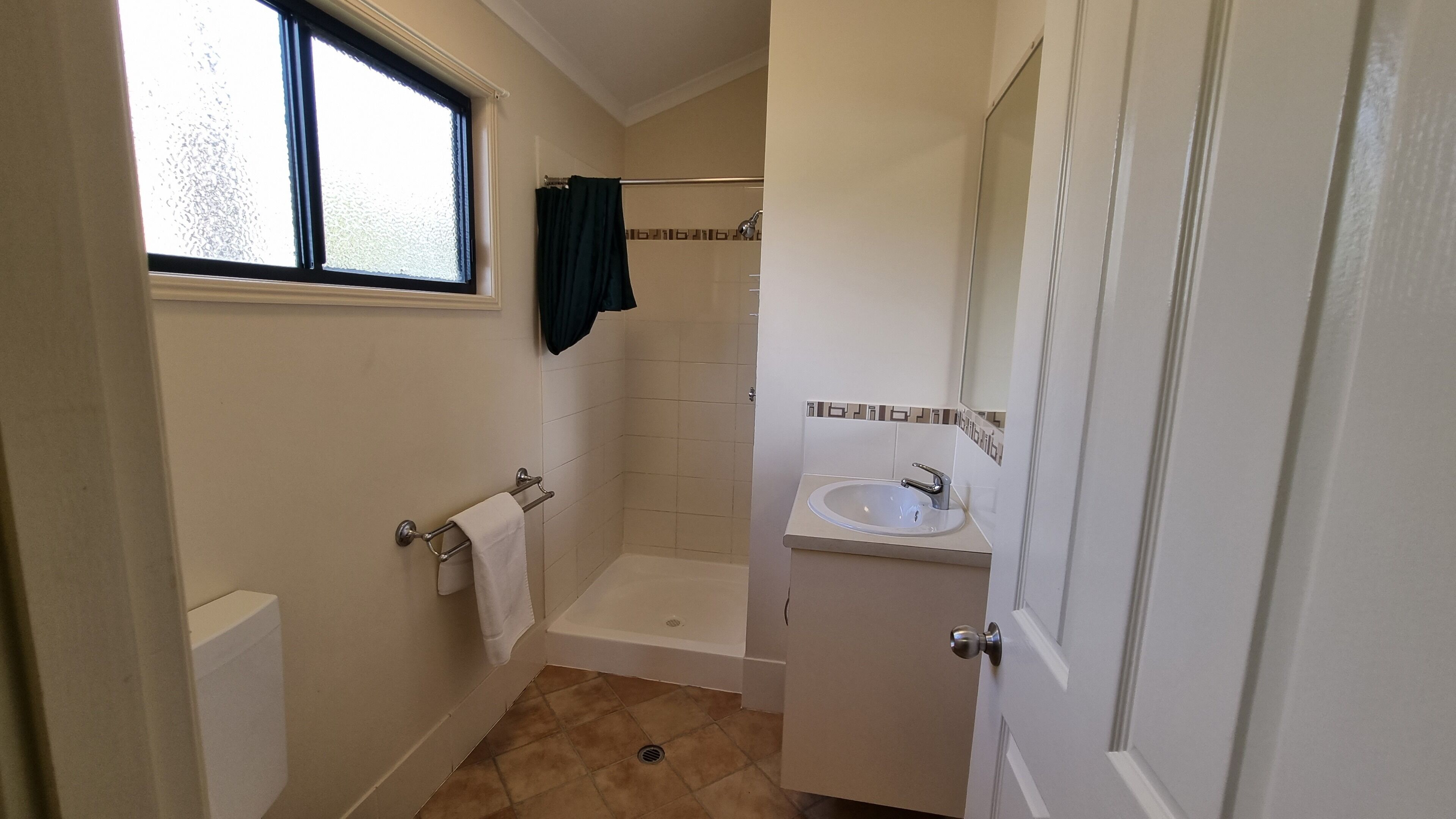 A small bathroom with a shower, a toilet, and a sink.