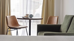 Una habitación con una mesa redonda, dos sillas y un sofá.