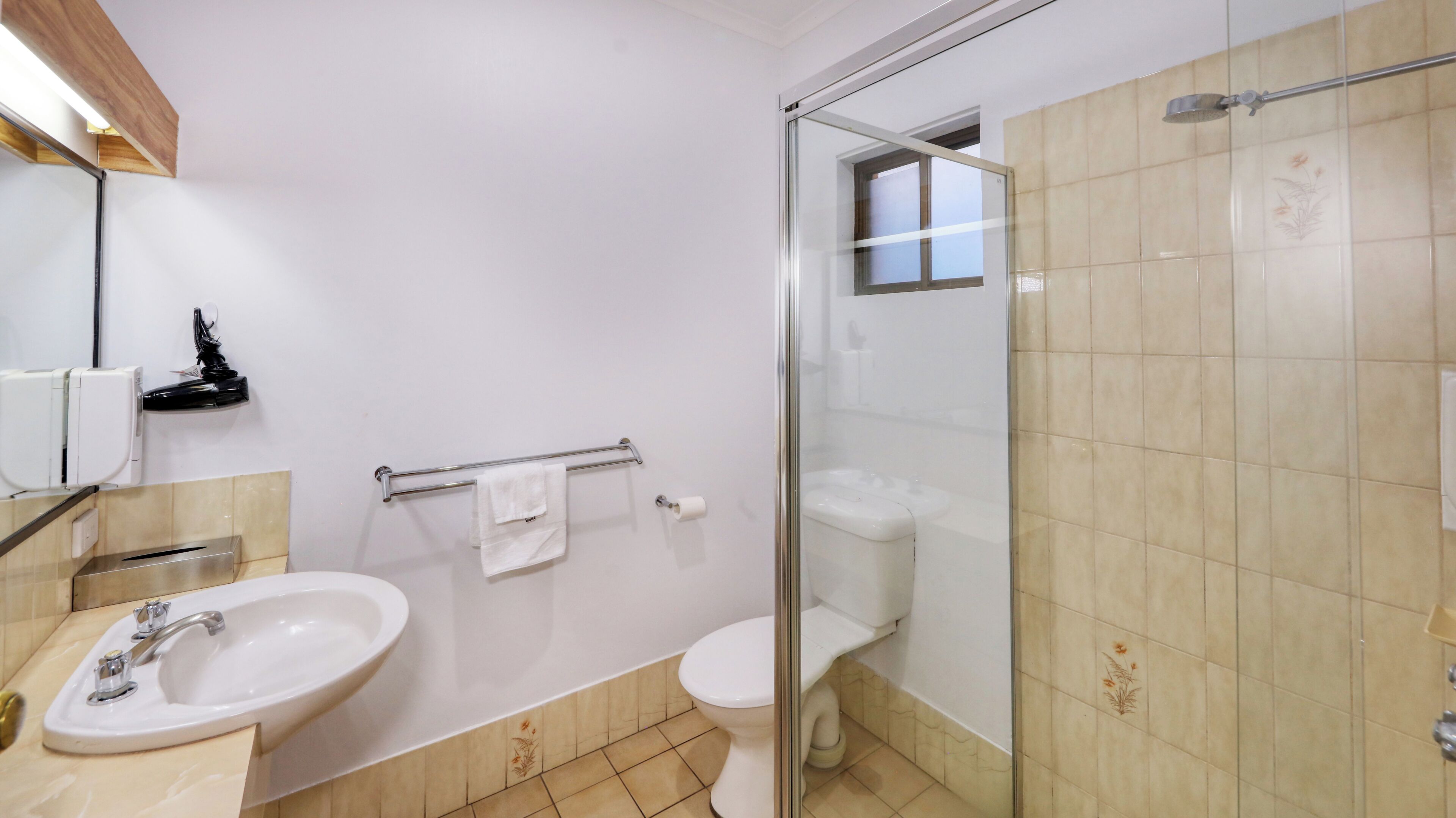 Ein Badezimmer mit Waschbecken, Toilette und einer Duschkabine.