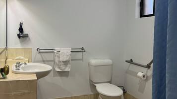 Un baño con lavamanos, inodoro y una pequeña ventana.