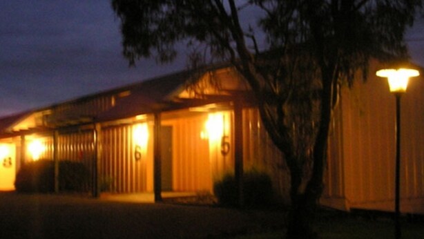 Un edificio con varias puertas y ventanas, iluminado por luces exteriores.