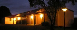 A building with multiple doors and windows, illuminated by exterior lights.