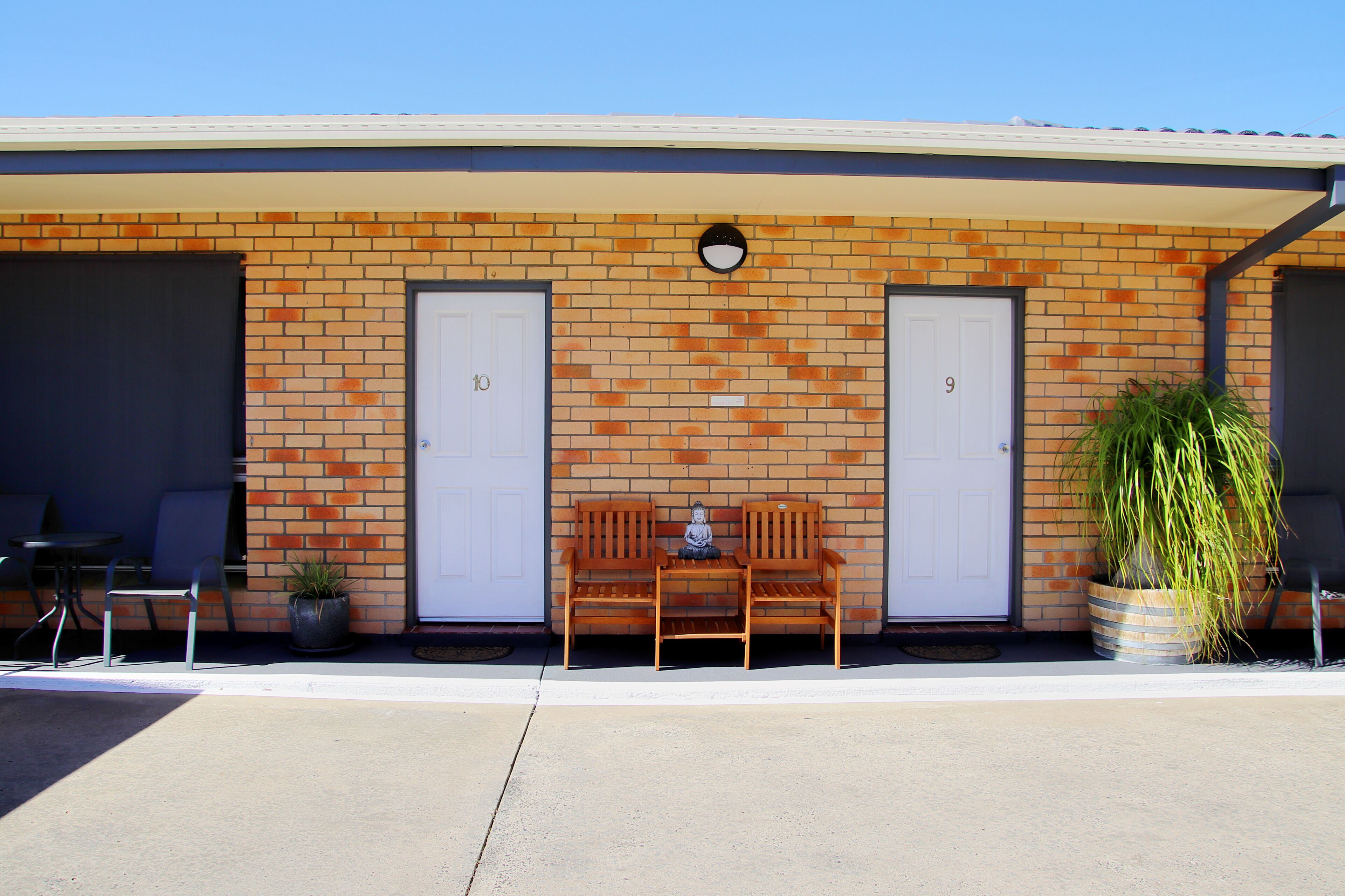 A building with two doors, numbered 9 and 10, and a bench in front.