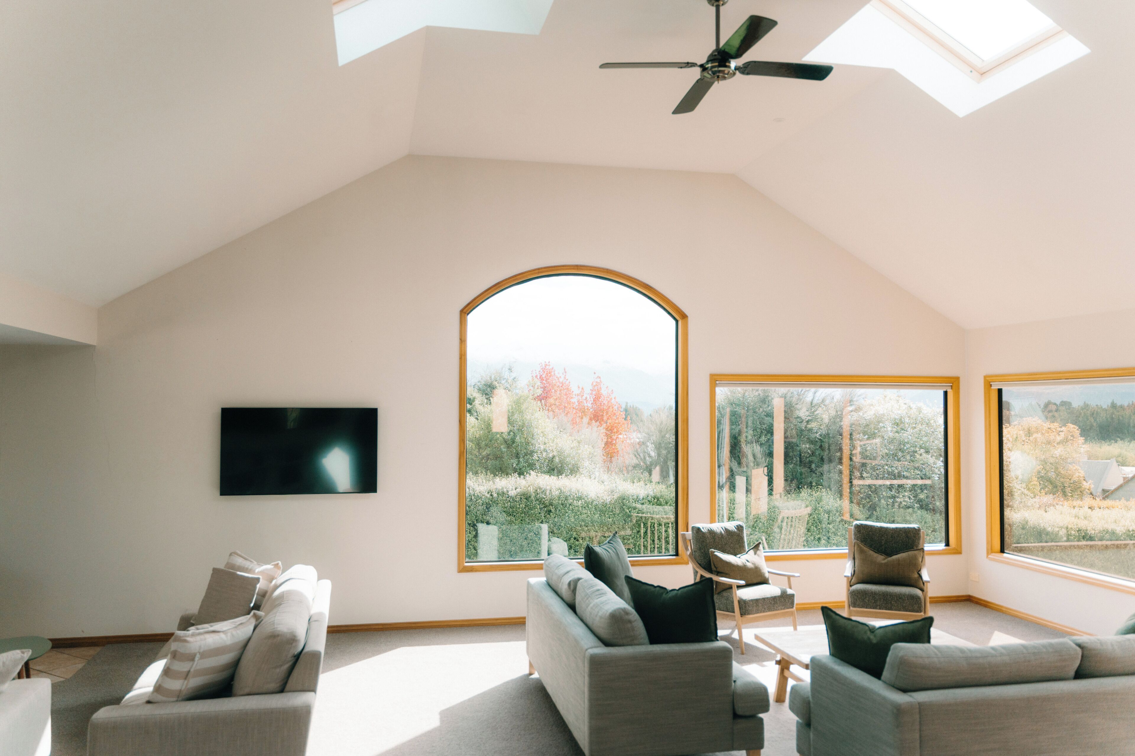 Un loft amplio con techo alto, ventanas grandes y ventilador de techo.