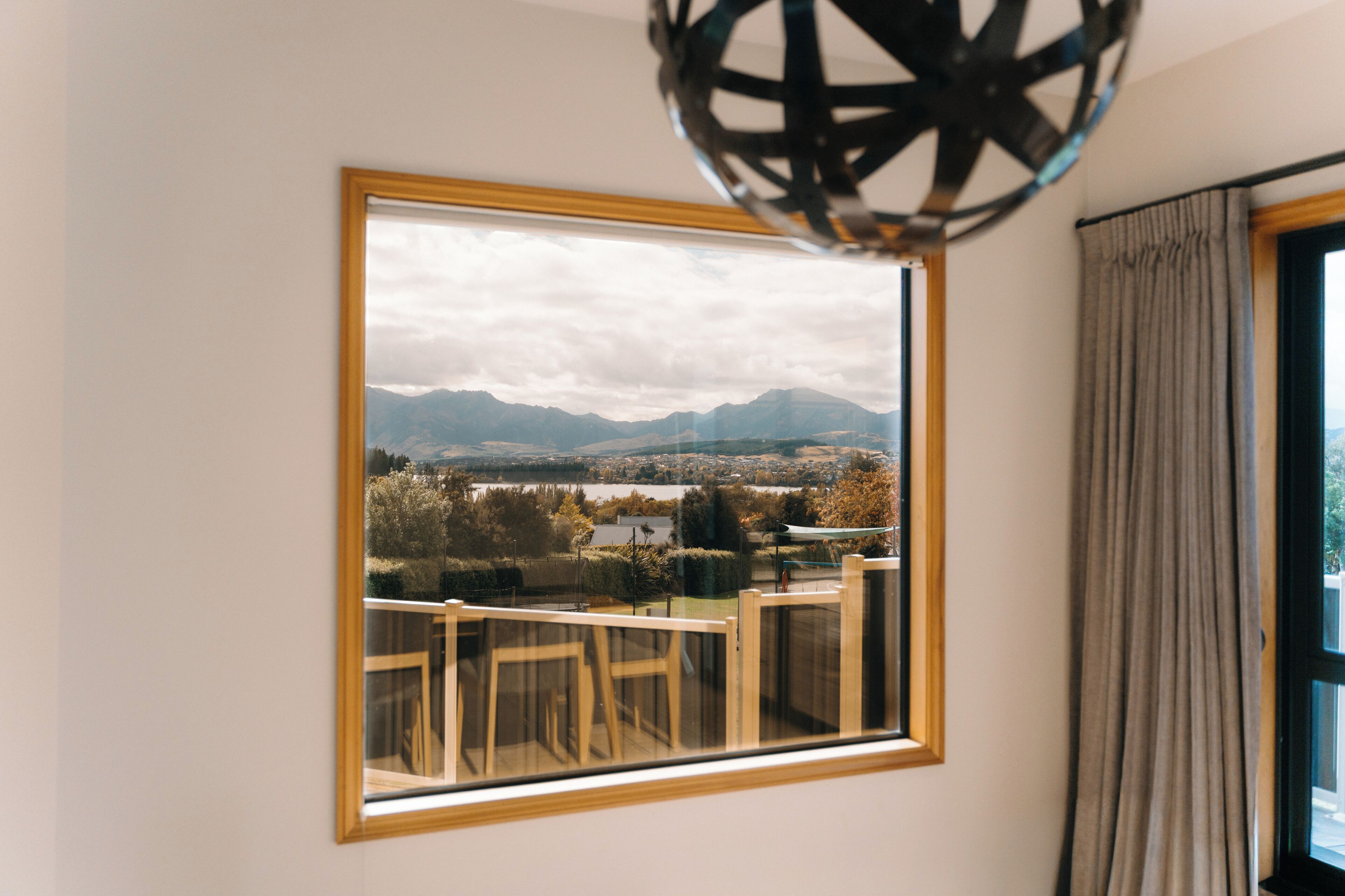 A framed photograph of a balcony with a view of mountains and a lake.