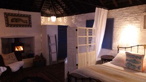 Ein gemütliches Zimmer mit Kamin, einem Himmelbett und rustikalem Charme.