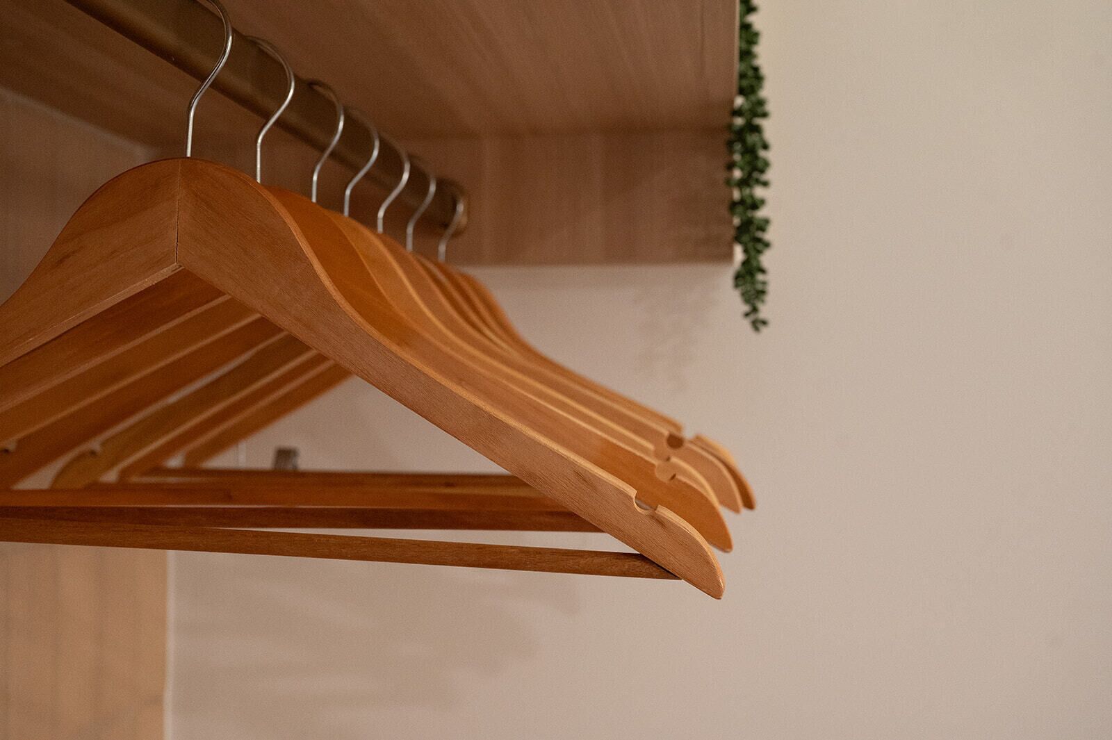 Een houten kledingrek met meerdere ophanghaakjes.