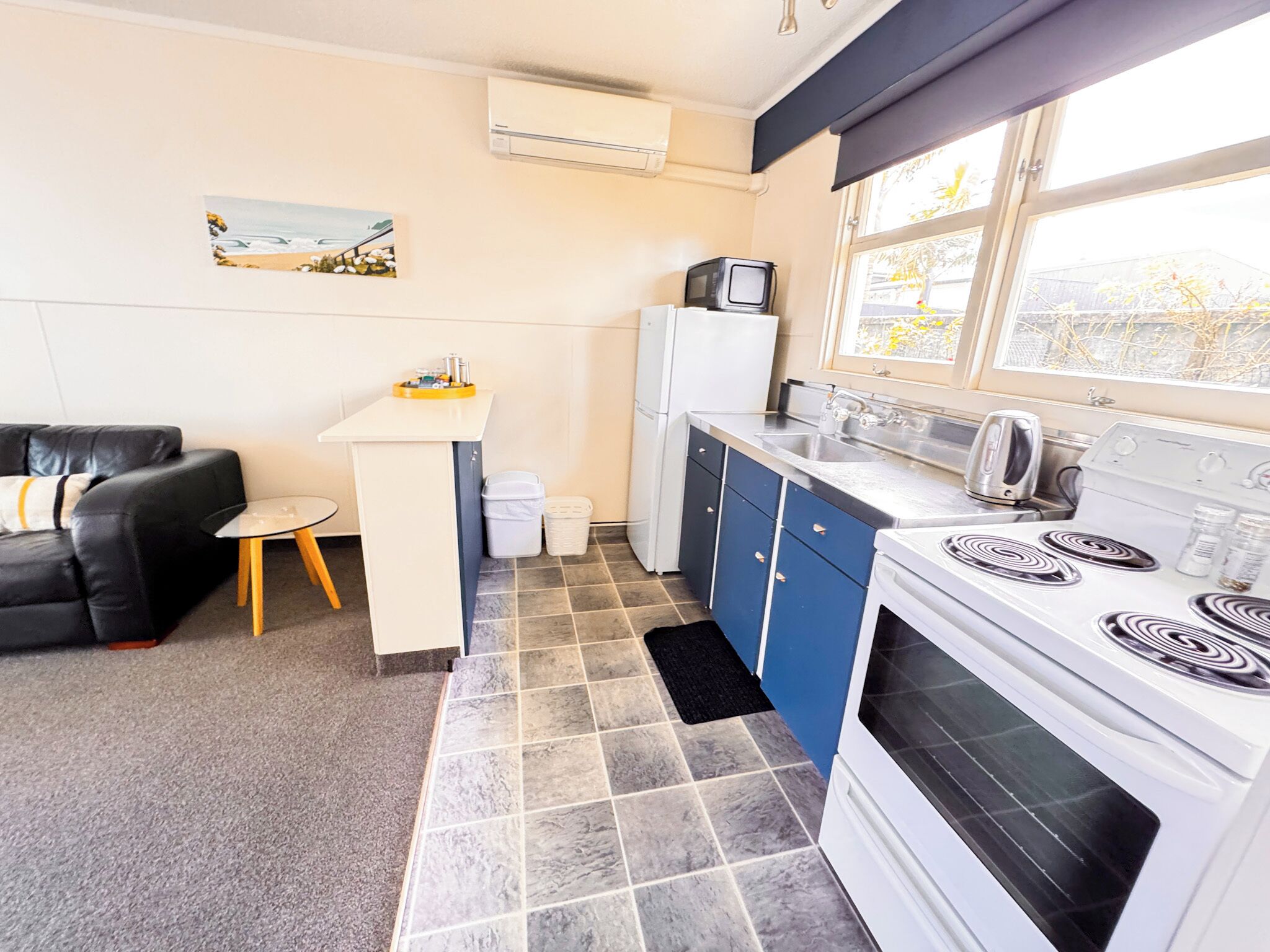 A compact kitchen with a stove, sink, and a small dining area.