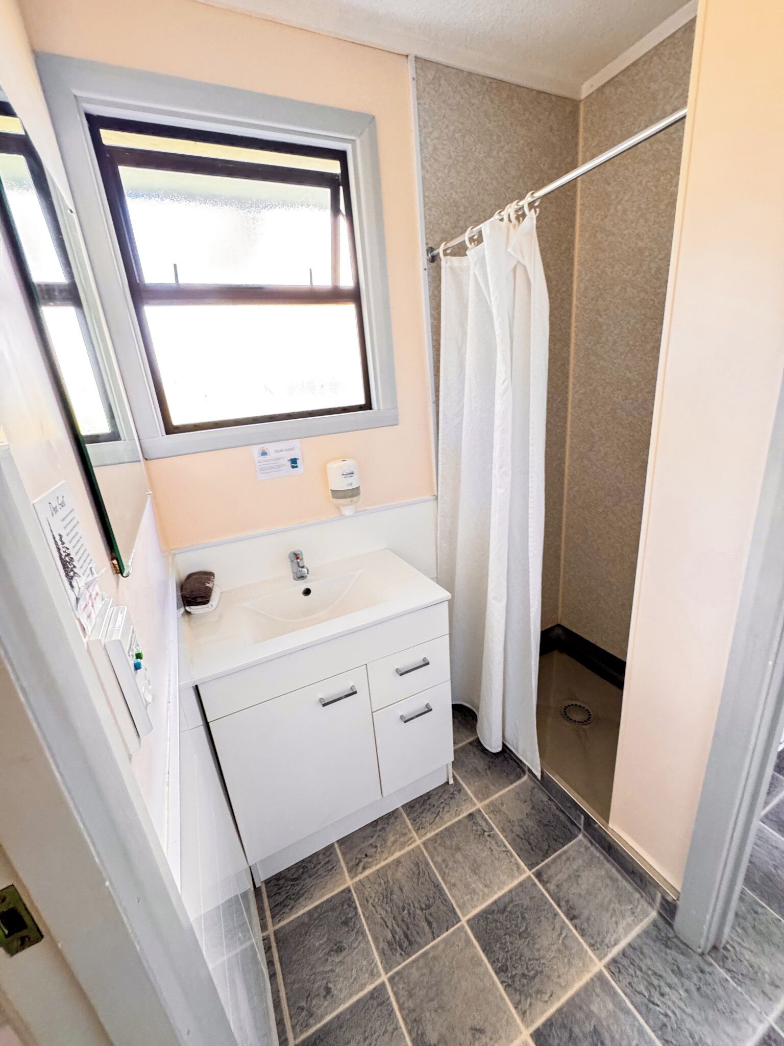 A bathroom with a sink, mirror, and shower curtain.