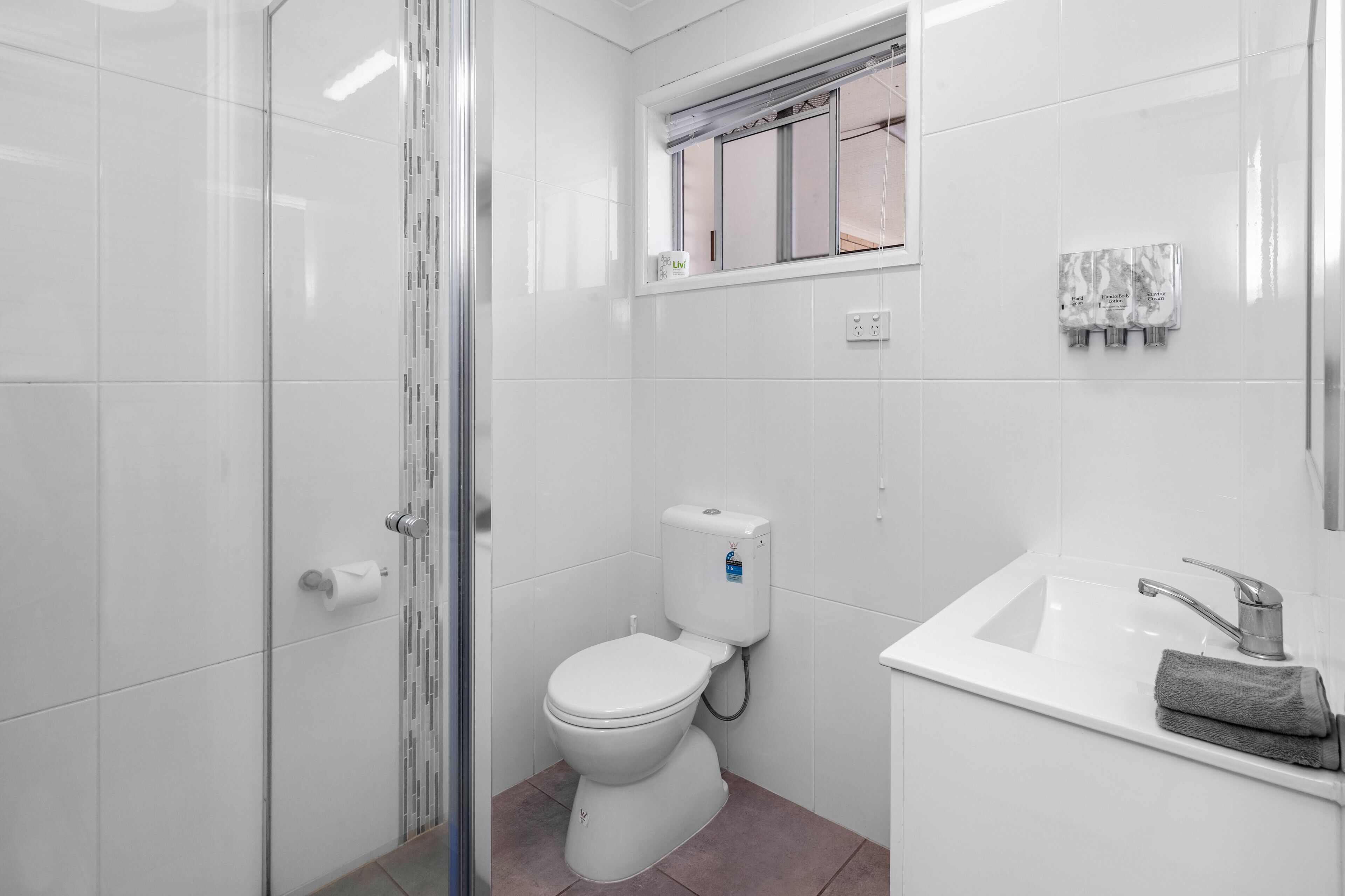 A modern bathroom with a toilet, sink, and shower.