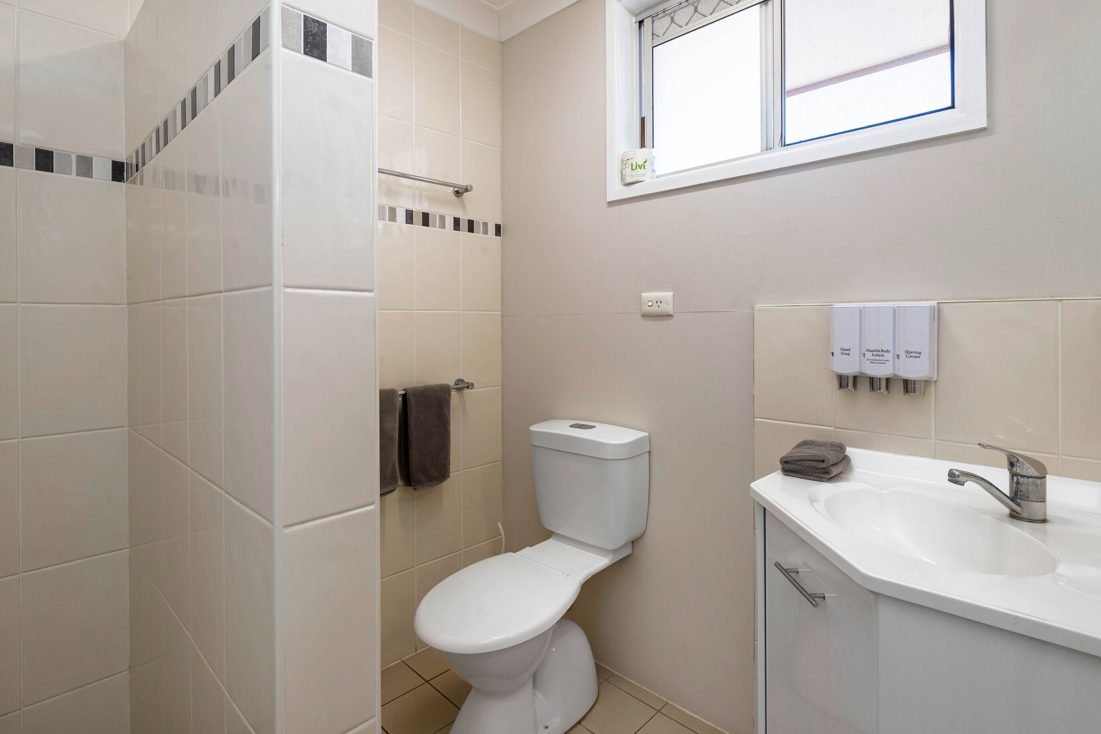 Een badkamer met toilet, wastafel en douche.