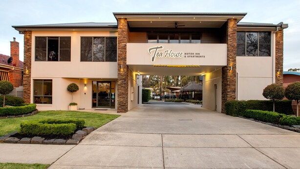 Un edificio moderno con un letrero que dice 'Tea House Motor Inns & Apartments'.