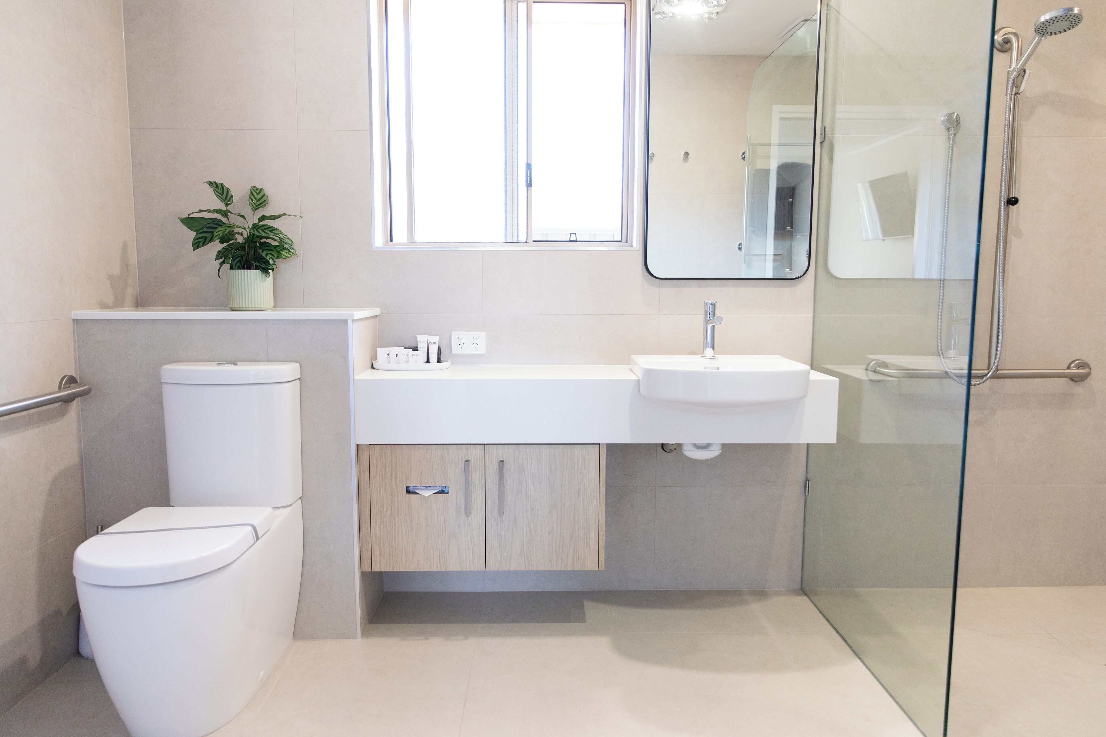 A modern bathroom with a toilet, sink, and shower.