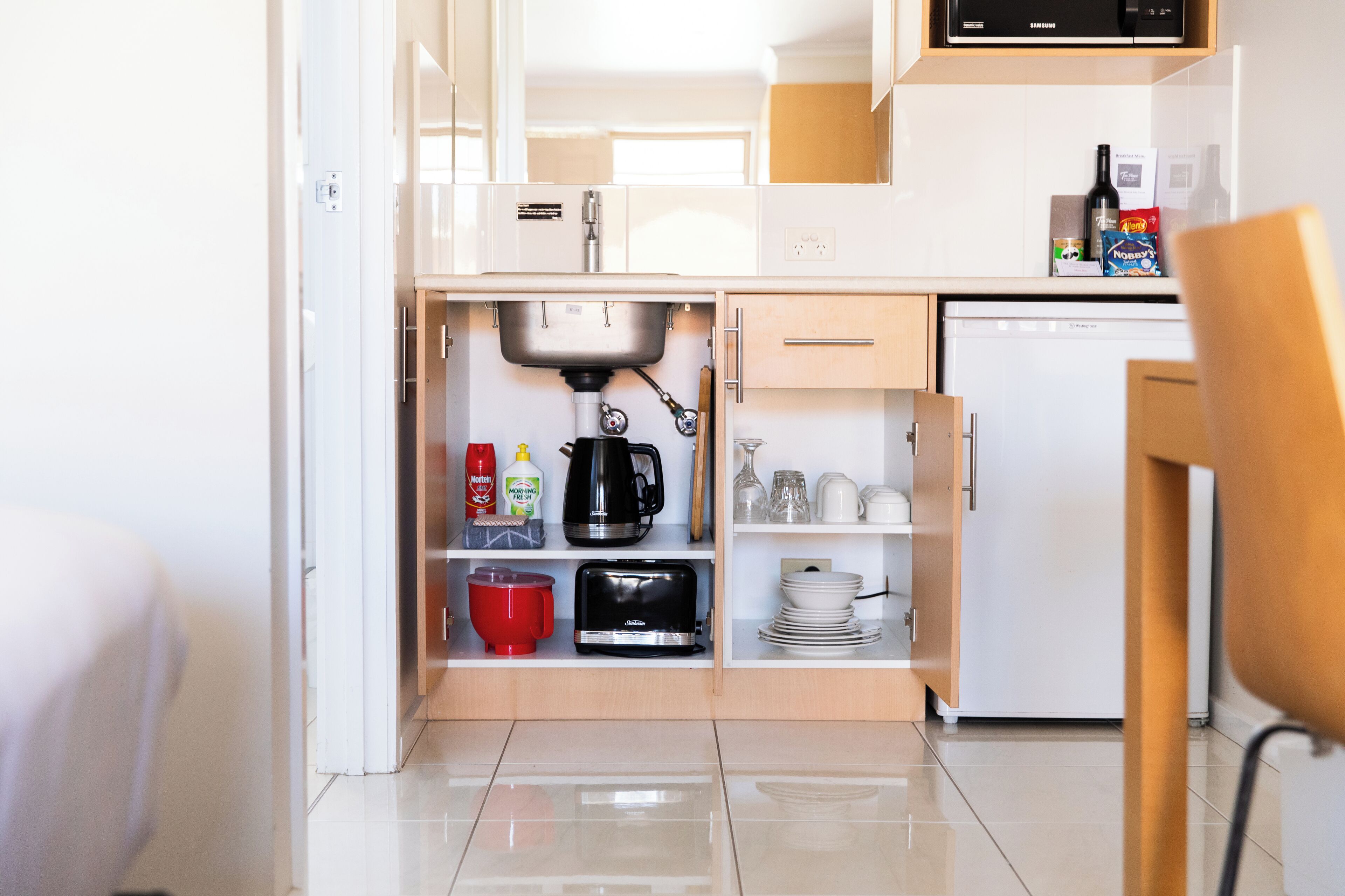 Una cocina compacta equipada con lavavajillas, cafetera y tostadora.