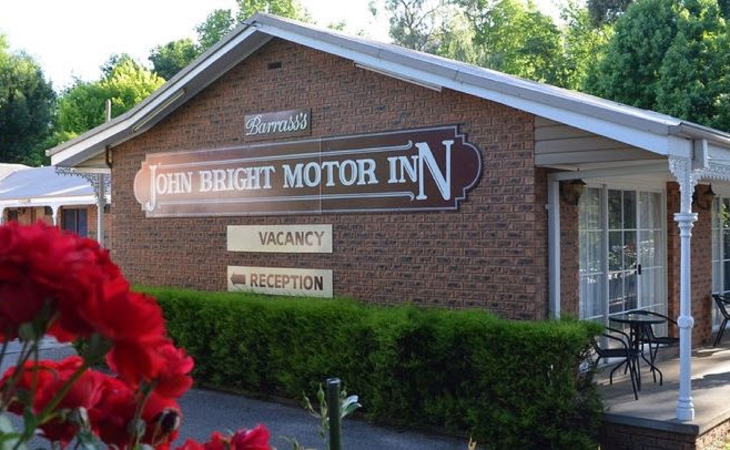 Un edificio con un letrero que dice "John Bright Motor Inn" y un letrero de "Disponibilidad" debajo.