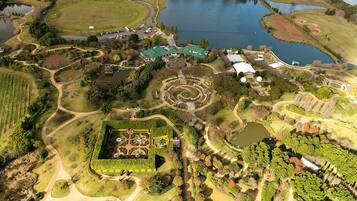 Vista aérea de un parque con un lago extenso, senderos sinuosos y varios edificios.