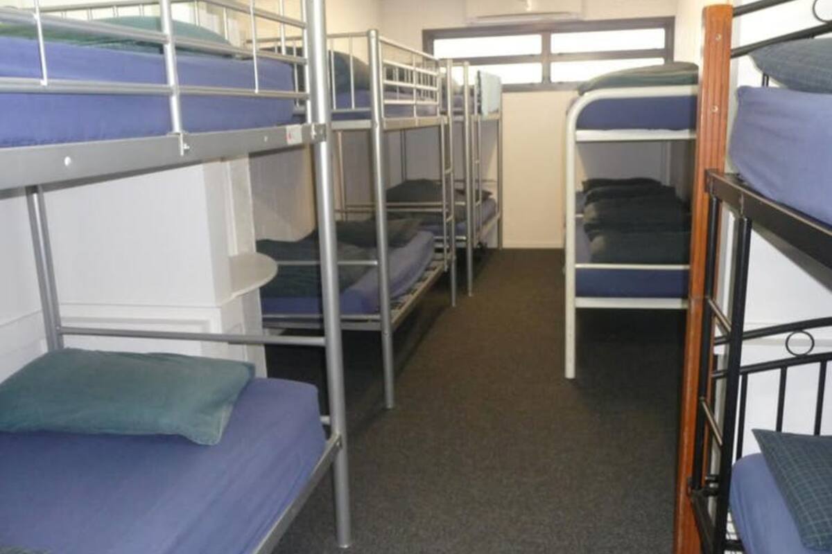 Un dormitorio con literas dispuestas en dos filas.