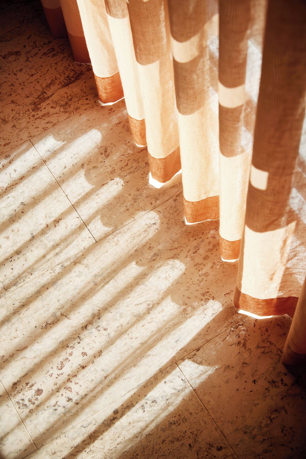 Un gros plan d’un plancher en bois avec un motif d’ombres.