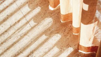 A close-up of a wooden floor with a shadow pattern.