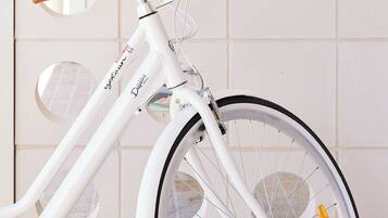 A white bicycle with a digital display, a front suspension fork, and a rear derailleur.